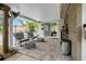 Relaxing covered patio with comfortable seating, lush landscaping, and view of the swimming pool at 7909 Canna Dr, Port Richey, FL 34668