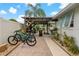 A delightful outdoor patio featuring a wooden pergola, tropical plants, and two bicycles at 7909 Canna Dr, Port Richey, FL 34668