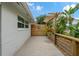 Side yard features a concrete patio with a wooden fence and lush greenery at 7909 Canna Dr, Port Richey, FL 34668