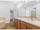 A bright bathroom features double sinks, wood cabinets, a large mirror, and natural light at 8015 Hampton Glen Dr, Tampa, FL 33647