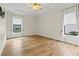 A bright bedroom features wood flooring, windows, and a ceiling fan at 8015 Hampton Glen Dr, Tampa, FL 33647