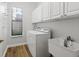 Functional laundry room with a sink, cabinets for storage, and a washer/dryer at 8015 Hampton Glen Dr, Tampa, FL 33647