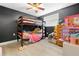 Toddler's bedroom, featuring a bunk bed, dresser, black accent wall, and a window that provides lots of natural light at 9126 Greenbriar Ln, Port Richey, FL 34668