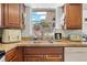 Kitchen featuring wood cabinets and a window with an undermount sink providing natural light at 9126 Greenbriar Ln, Port Richey, FL 34668