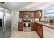 Galley kitchen featuring stainless steel appliances, wood cabinets, and lots of natural light from a window at 9126 Greenbriar Ln, Port Richey, FL 34668