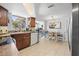 This is a kitchen that features a dining area with dark wood cabinets, white appliances, and lots of natural light at 9126 Greenbriar Ln, Port Richey, FL 34668