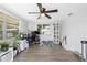Bright living room featuring wood-look flooring, a ceiling fan, and large windows for lots of natural light at 9126 Greenbriar Ln, Port Richey, FL 34668
