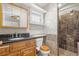 Bathroom with granite countertop, wooden cabinets, toilet with bidet and shower with marble tile at 1021 15Th St, Palm Harbor, FL 34683