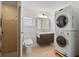 Bathroom with a standing shower, stacked washer and dryer, and floating vanity at 1021 15Th St, Palm Harbor, FL 34683