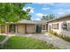 Exterior view of the home with charming brick walkway and covered entry at 1021 15Th St, Palm Harbor, FL 34683
