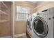 Bright laundry room features washer and dryer, storage shelving and a window that allows for natural light at 1021 15Th St, Palm Harbor, FL 34683