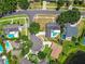 A scenic aerial view of a neighborhood showcasing lush green lawns, mature trees, and inviting swimming pools in backyards at 10408 Butia Pl, Tampa, FL 33618