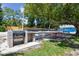 Inviting picnic area with charcoal grill and picnic tables, adjacent to a beach volleyball area by the lake at 10408 Butia Pl, Tampa, FL 33618