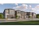 Row of modern townhomes featuring attached garages and neutral color scheme at 10804 Keato Beach Ct, Tampa, FL 33647