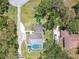Aerial view of the home showing its layout with a pool and a large yard surrounded by mature trees at 11203 Killearn Ct, Riverview, FL 33569