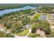 Aerial view of the home situated in a lush, wooded area near a lake, showcasing its serene and private setting at 11203 Killearn Ct, Riverview, FL 33569