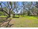 Beautiful backyard with a gazebo, mature trees, and lush green grass for leisure at 11203 Killearn Ct, Riverview, FL 33569