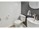 Half-bathroom featuring black and white beadboard walls, a toilet, and a modern, vessel-style sink at 11203 Killearn Ct, Riverview, FL 33569