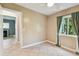 Neutral-toned bedroom featuring tile flooring, a ceiling fan, and a window with bright light and an adjacent bathroom at 11203 Killearn Ct, Riverview, FL 33569