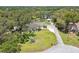 Landscaped front yard with mature trees and a long driveway leading to a charming home with a screened-in pool at 11203 Killearn Ct, Riverview, FL 33569
