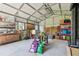 Spacious garage featuring metal walls, ample shelving, work benches, and two windows at 11203 Killearn Ct, Riverview, FL 33569
