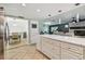 Kitchen island with white cabinets, marble counters, and stainless appliances in background at 11203 Killearn Ct, Riverview, FL 33569