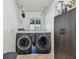 Bright laundry room featuring a side-by-side washer and dryer set with a black storage cabinet at 11203 Killearn Ct, Riverview, FL 33569