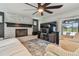 Comfortable living room with painted brick fireplace, large television, and ceiling fan at 11203 Killearn Ct, Riverview, FL 33569