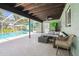 View of the covered patio with lounge furniture and access to the screened-in pool area at 11203 Killearn Ct, Riverview, FL 33569