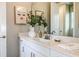 Well-lit bathroom featuring a white vanity with modern hardware, quartz countertop, and decorative accessories at 11236 Kingly Ln, Odessa, FL 33556