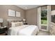 Cozy bedroom with neutral tones, plush bedding, soft lighting, and a view of the outdoors at 11236 Kingly Ln, Odessa, FL 33556