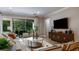 Bright living room featuring neutral decor, wood floors, modern furniture, and views to a screened outdoor living space at 11236 Kingly Ln, Odessa, FL 33556