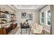 Well-lit home office with custom shelving, modern desk, and comfortable seating, perfect for remote work at 11236 Kingly Ln, Odessa, FL 33556