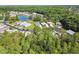 An aerial view showcases the community's serene setting with lush greenery and a tranquil pond at 11446 Sinatra Ct, New Port Richey, FL 34654