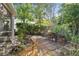 Outdoor patio with brick pavers, lush foliage, fountain, and garden decor at 11446 Sinatra Ct, New Port Richey, FL 34654
