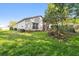 Lush backyard with healthy lawn, trees, flowering plants, and a screened-in porch at 11446 Sinatra Ct, New Port Richey, FL 34654
