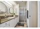 Clean bathroom with granite countertops, double mirrors, and a glass-enclosed shower at 11446 Sinatra Ct, New Port Richey, FL 34654