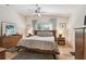 Well-lit bedroom featuring a ceiling fan, wooden bed frame, and complementing wooden furniture at 11446 Sinatra Ct, New Port Richey, FL 34654