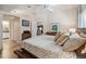 Light-filled bedroom with ceiling fan showcasing wood floors, and a view to the bathroom and kitchen at 11446 Sinatra Ct, New Port Richey, FL 34654