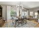 Bright dining room with modern chandelier, large window, and a view into the living area at 11446 Sinatra Ct, New Port Richey, FL 34654