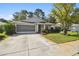 Single Gathering home boasts a screened garage, well maintained landscaping, and a beautiful lawn at 11446 Sinatra Ct, New Port Richey, FL 34654