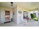 Inviting covered front porch featuring rocking chairs and a decorative front door at 11446 Sinatra Ct, New Port Richey, FL 34654