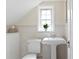 Bright bathroom features a pedestal sink, toilet, and window with a plant at 126 14Th Ne Ave, St Petersburg, FL 33701