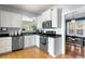 Kitchen featuring stainless steel appliances, white cabinets, dark counters, and hardwood floors at 126 14Th Ne Ave, St Petersburg, FL 33701