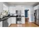 Bright kitchen features stainless steel appliances, white cabinetry, and hardwood floors at 126 14Th Ne Ave, St Petersburg, FL 33701