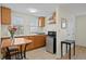 Compact kitchenette with wooden cabinets, stainless steel appliances, and a cozy dining area at 126 14Th Ne Ave, St Petersburg, FL 33701