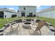 Inviting backyard featuring a stone fire pit with chairs, a lush lawn, and privacy fence at 13734 Whiskey Daisy Dr, Dade City, FL 33525