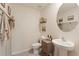 Stylish half bath with a pedestal sink, decorative accents, and neutral tones at 13734 Whiskey Daisy Dr, Dade City, FL 33525
