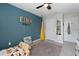 Charming bedroom with a cozy swing, playful decor, and a calming blue accent wall at 13734 Whiskey Daisy Dr, Dade City, FL 33525