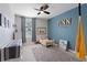 Charming bedroom featuring bright blue accent wall, comfortable bed and stylish bookcase at 13734 Whiskey Daisy Dr, Dade City, FL 33525